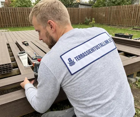 A builder fits brown composite decking to its frame. The boards are stored in the warm section of our Peetri warehouse.